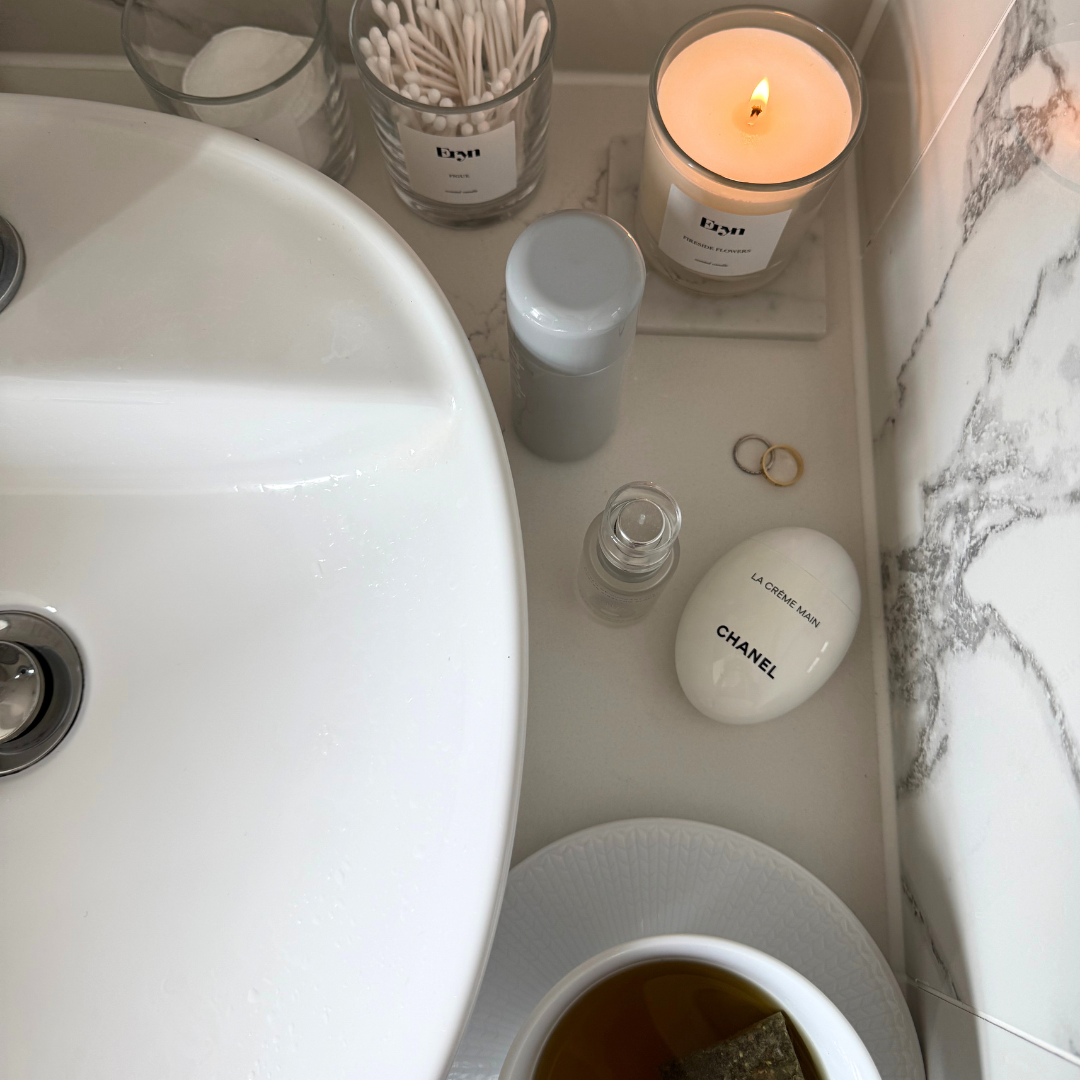 Bathroom counter with a luxury scented candle from Eryn Fragrances, soap, and other items.