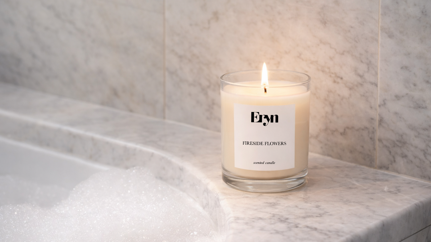 Fireside Flowers luxury candle by Eryn in minimalist glass vessel on a marble surface